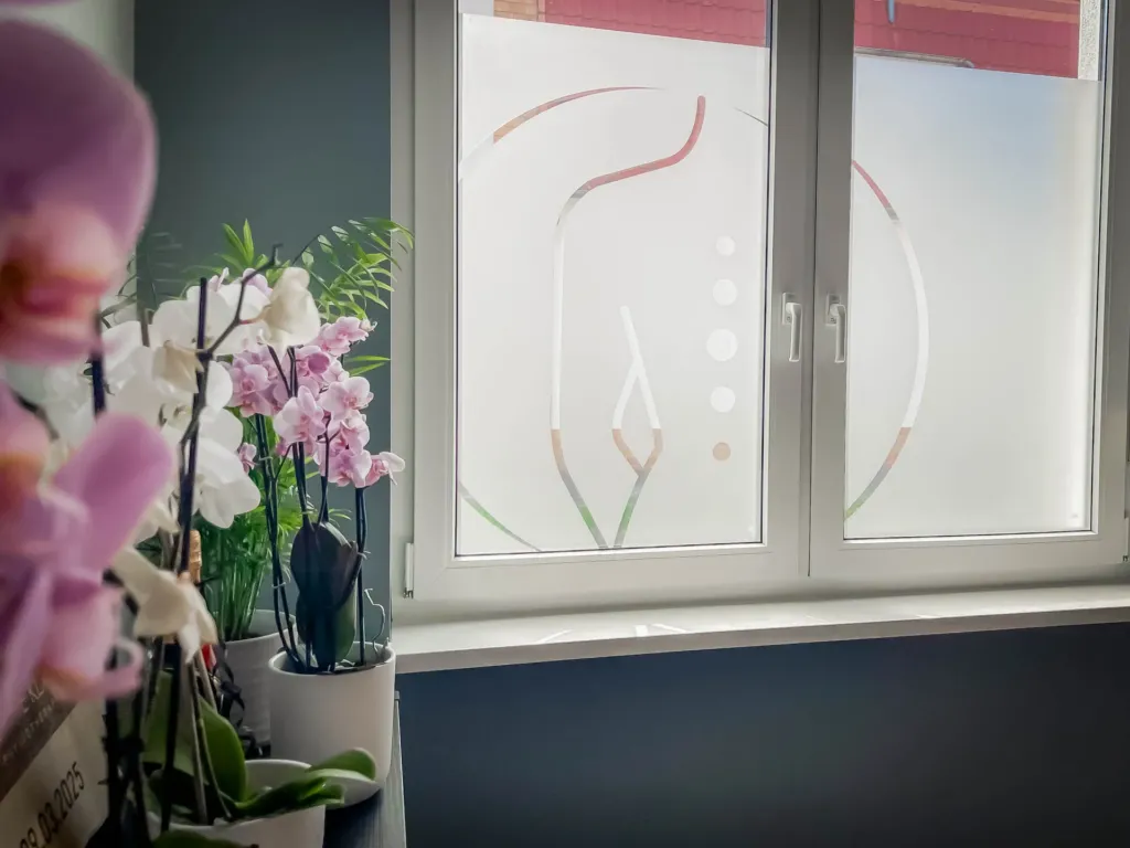 Fensterfolie mit individuellem Praxislogo bei Physiotherapie Sophie Klaus in Gernrode, Eichsfeld, mit Orchideen im Vordergrund
