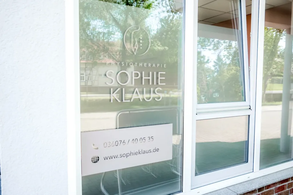 Eingangsbeschriftung der Physiotherapie Sophie Klaus mit Logo, Praxisname und Kontaktdaten auf Glastür